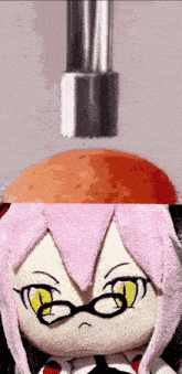 a stuffed doll with glasses and a pink hair looks at an orange object