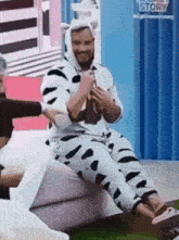 a man in a cow costume is sitting on a couch in front of a toy story sign