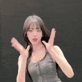 a woman in a gray tank top is making a funny face
