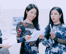 two women standing next to each other with one wearing a shirt that says light