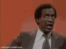 a man in a suit and tie is making a face .