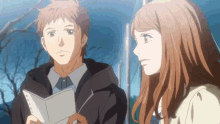 a man and a woman are looking at each other while the man is reading a book