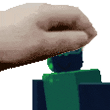 a pixelated image of a hand holding a green cube