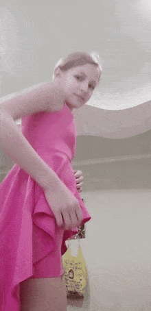 a young girl in a pink dress is standing in front of a yellow bag that says shampoo