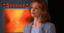 a woman in a blue jacket is standing in front of a screen that says ' nnnnnn ' on it