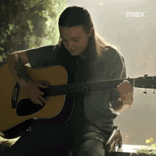 a man playing an acoustic guitar with the word max on the bottom