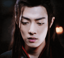 a close up of a man 's face with long hair and pink lips