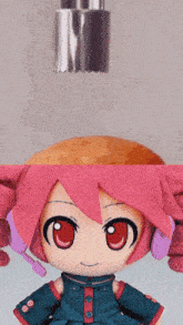 a stuffed doll with pink hair and red eyes is sitting next to a bottle