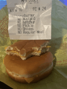 a mcdonald 's receipt for a cheeseburger with a slice taken out of it