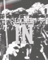 a black and white photo of a crowd with the words " lock it in " visible