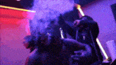 a man is smoking a cigarette in a dark room with a lot of smoke coming out of his mouth .