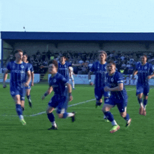 a group of soccer players are running on a field and one of their uniforms says micro