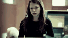 a woman in a black shirt is sitting in front of a computer