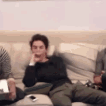 a group of people are sitting on a couch with their hands on their chins .