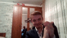a man in a suit is smiling in front of a mirror