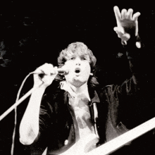a man is singing into a microphone while playing a guitar
