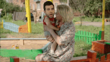 a woman is holding a baby with a man 's head on it