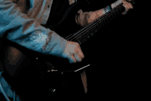 a close up of a person playing an electric guitar