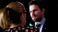 a man and a woman are looking into each other 's eyes in a dark room .