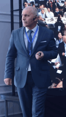 a man in a suit and tie stands in front of a group of people