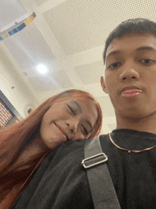 a man and a woman are posing for a picture and the woman is laying her head on the man 's shoulder