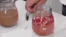 a person is opening a jar of food with a knife on a table .