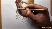 a person is drawing iron man with a pencil on a piece of paper