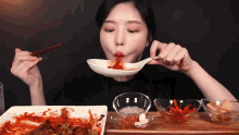 a woman is eating a bowl of food with a spoon
