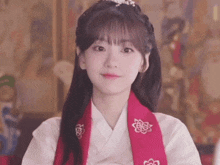 a woman wearing a white shirt and a red scarf with flowers on it