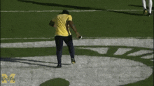 a man in a yellow shirt is running on a football field with goblog written on the bottom