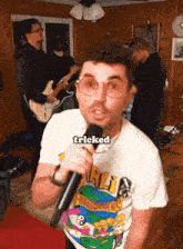 a man singing into a microphone with the word tricked on his shirt