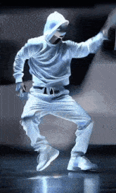 a man in a white hoodie and white pants is dancing