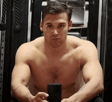 a shirtless man is taking a picture of himself with a cell phone