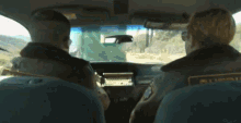 a man in a sheriff 's uniform is sitting in the driver 's seat of a car