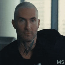 a man with a tattoo on his neck is looking at the camera