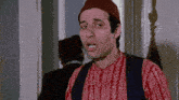 a man wearing a red hat and a red shirt is making a face