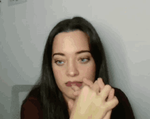 a close up of a woman 's face with her hand on her face .