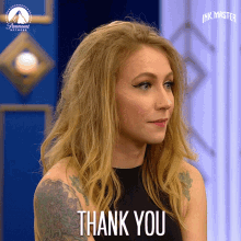 a woman with tattoos on her arms says thank you