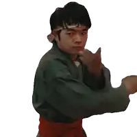 a young man wearing a headband and a green karate uniform is making a fist