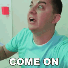 a man in a blue shirt is making a face and says come on