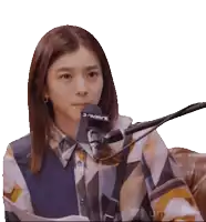 a woman sitting in front of a microphone that says j-wave on it