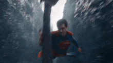 a man in a superman costume is running down a street