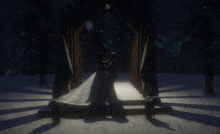 a bride and groom are dancing in a snowy forest