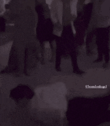 a man is laying on the floor in front of a crowd of people dancing ..