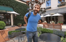 a man in a blue shirt stands in front of a building that says seco