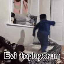 a child is running in a room with the words " evi topluyorum " written on it