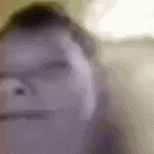 a close up of a man 's face with his hand on his forehead .