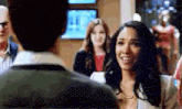 a man and a woman are standing next to each other in a room and smiling .