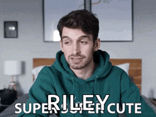a man wearing a green hoodie with the words riley cute written on it