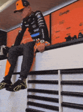 a man sits on a shelf in front of a google wall